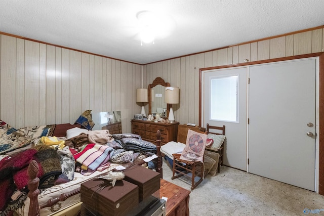 bedroom featuring carpet flooring, wood walls, and a textured ceiling