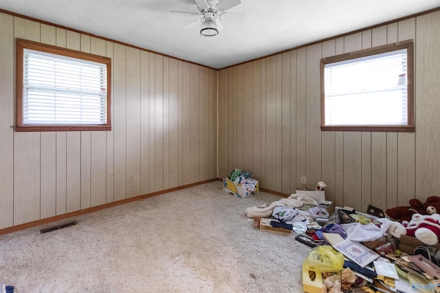 carpeted spare room featuring a ceiling fan and visible vents