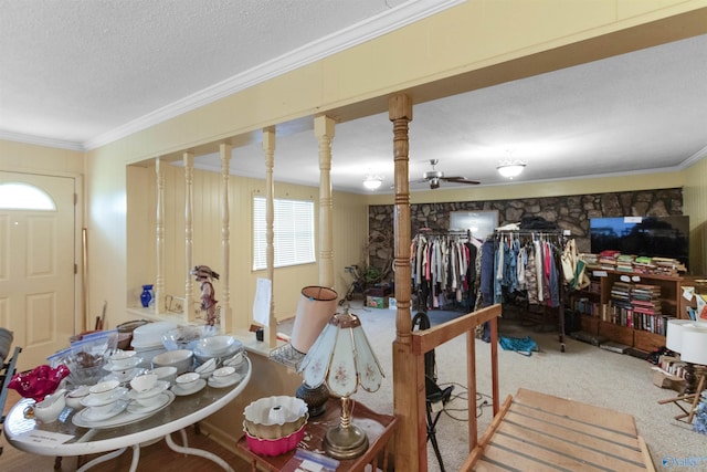 interior space with a textured ceiling, ornamental molding, ceiling fan, and carpet