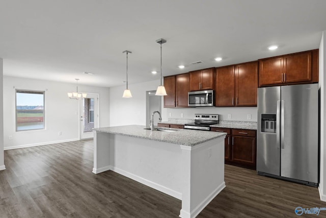 kitchen featuring an island with sink, appliances with stainless steel finishes, dark wood-type flooring, and sink