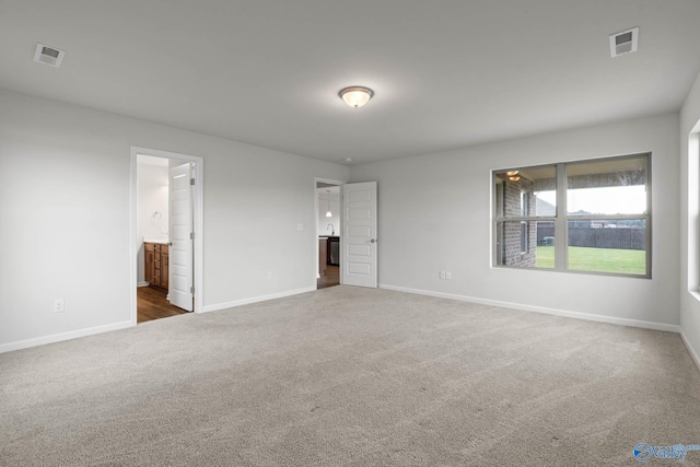 unfurnished bedroom with dark carpet and ensuite bathroom