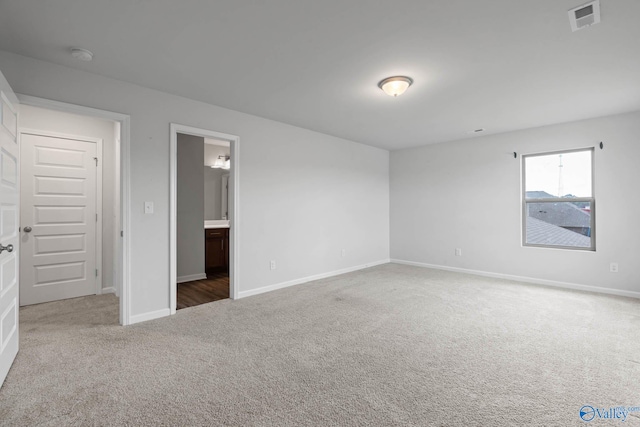 unfurnished bedroom featuring carpet and ensuite bath