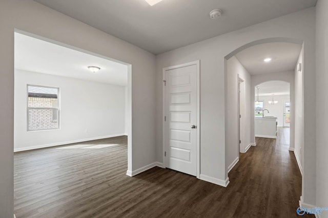 corridor with dark hardwood / wood-style flooring