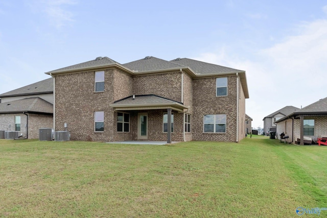 back of house featuring a lawn, cooling unit, and a patio area