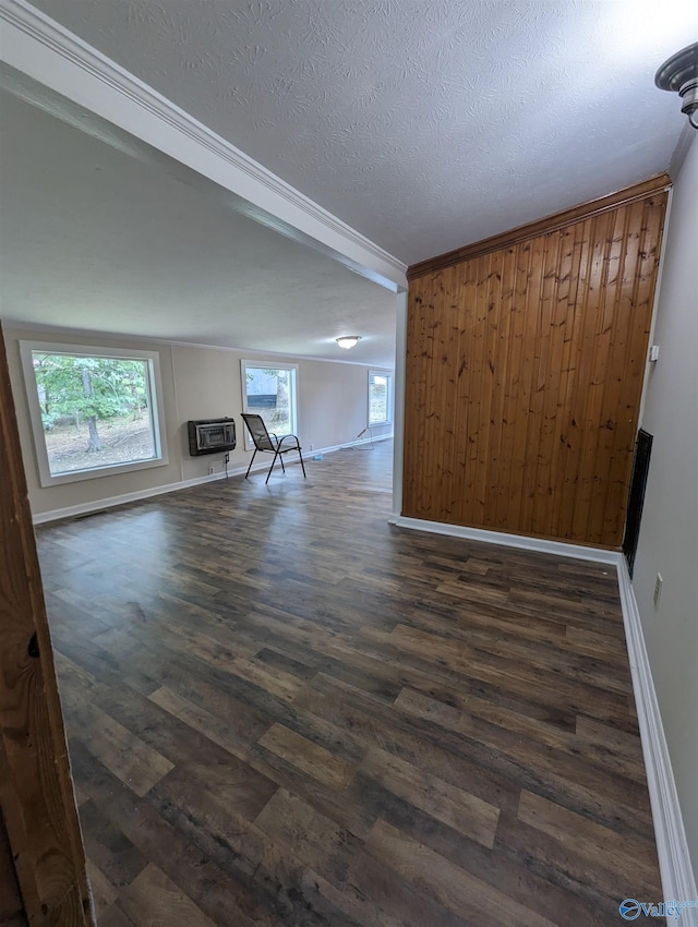 interior space featuring a textured ceiling, a wall mounted air conditioner, wood-type flooring, and ornamental molding