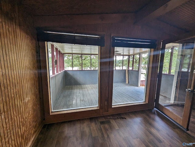 unfurnished sunroom featuring lofted ceiling with beams