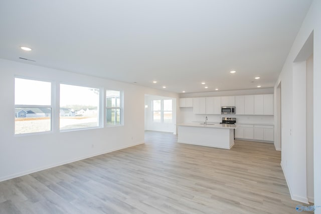 unfurnished living room featuring light hardwood / wood-style floors and sink