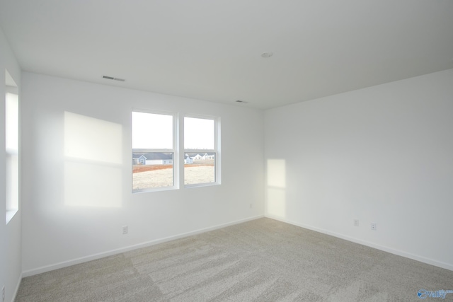 unfurnished room featuring light colored carpet