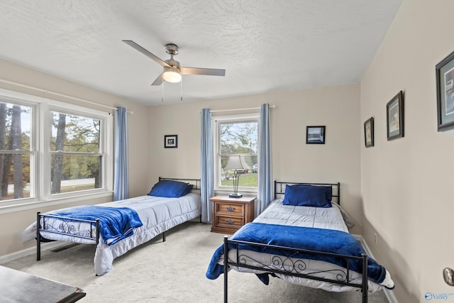 carpeted bedroom with ceiling fan and a textured ceiling