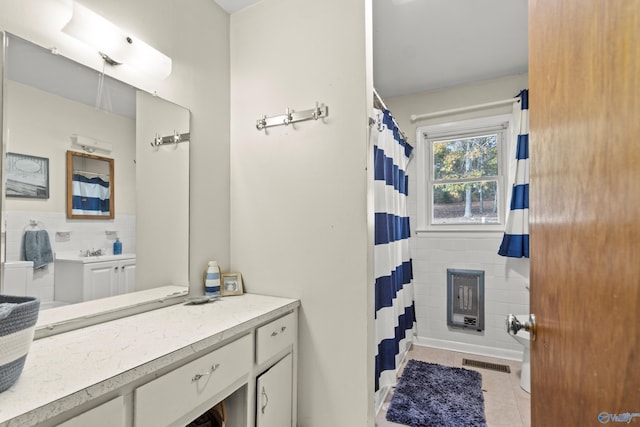 bathroom featuring tile patterned flooring, vanity, and tile walls