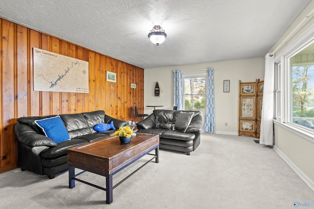 carpeted living room with wood walls and a textured ceiling