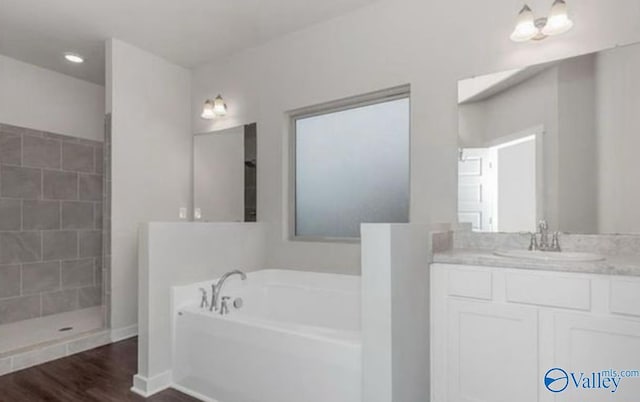 full bathroom featuring vanity, a bath, wood finished floors, and a tile shower