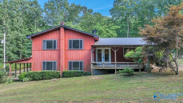 back of house with a deck and a lawn