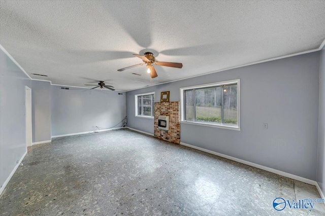 spare room featuring ceiling fan, heating unit, and a textured ceiling