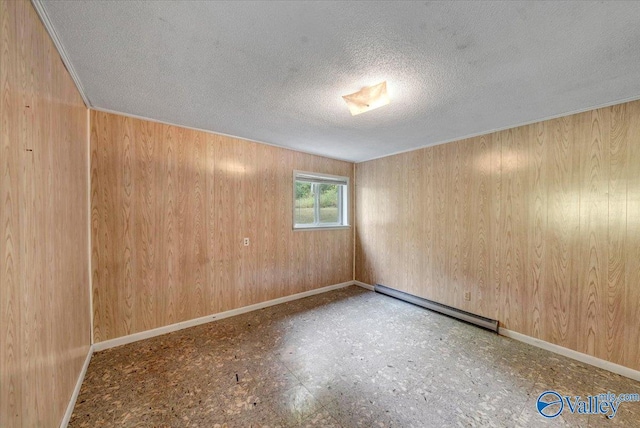 spare room with a baseboard heating unit and a textured ceiling