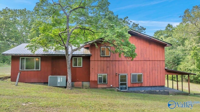 view of side of property with a yard and central air condition unit