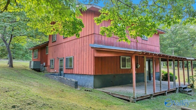 view of property exterior with central AC unit, a yard, and a deck