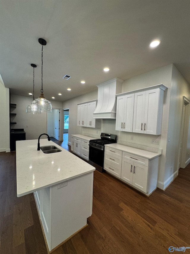 4829 Whorton Bend Rd, Gadsden, AL 35901 - kitchen with gas range, custom range hood, white cabinets, a kitchen island with sink, and recessed lighting