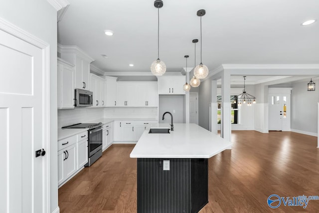 kitchen with stainless steel appliances, white cabinetry, sink, dark wood-type flooring, and a kitchen island with sink