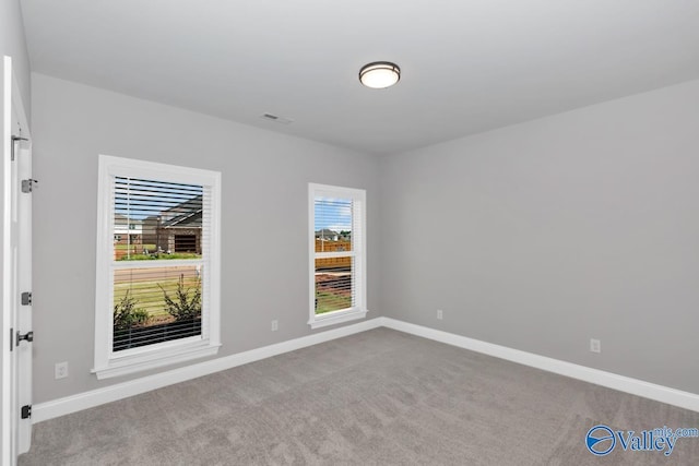 carpeted empty room with baseboards and visible vents