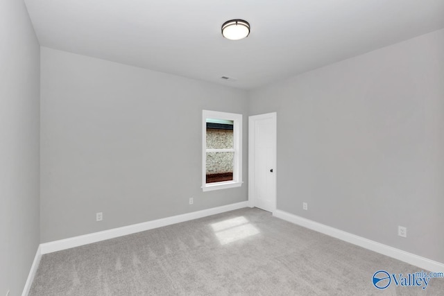 carpeted spare room with baseboards