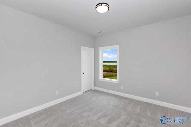 empty room featuring baseboards, visible vents, and carpet flooring
