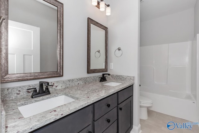 full bathroom with double vanity, a sink, toilet, and tile patterned floors