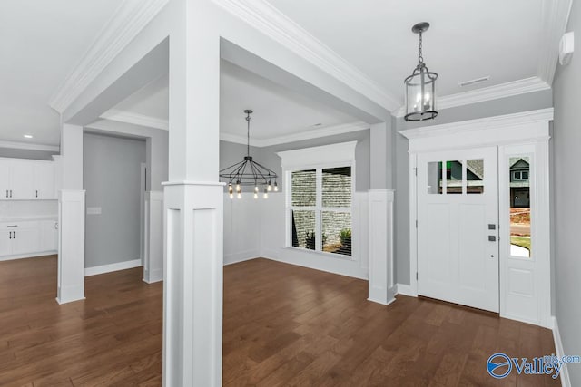 foyer entrance featuring crown molding, dark hardwood / wood-style flooring, and an inviting chandelier