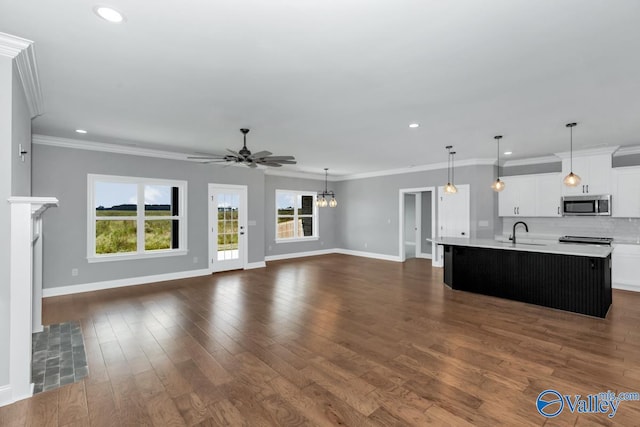 unfurnished living room featuring ornamental molding, ceiling fan, dark hardwood / wood-style floors, and sink