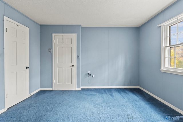 carpeted empty room featuring a textured ceiling