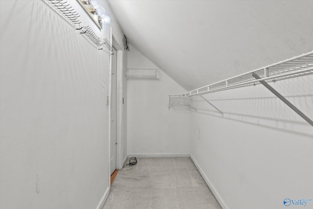 spacious closet with light colored carpet and lofted ceiling