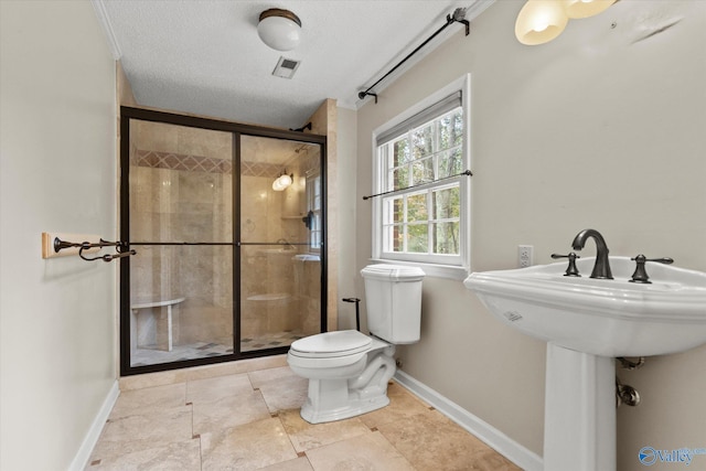 bathroom with toilet, an enclosed shower, and a textured ceiling