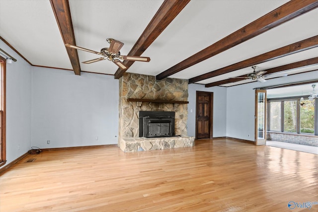 unfurnished living room featuring a fireplace, beam ceiling, light hardwood / wood-style flooring, and ceiling fan