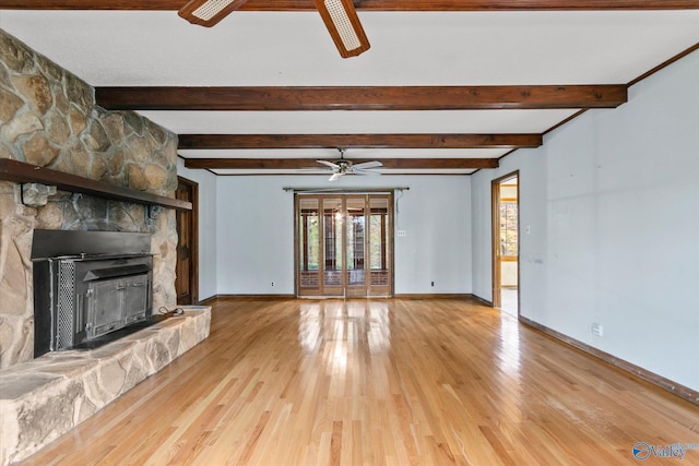 unfurnished living room with a fireplace, hardwood / wood-style floors, ceiling fan, and beam ceiling