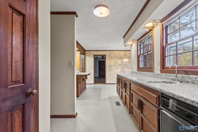 kitchen with light stone countertops, sink, dishwasher, pendant lighting, and a textured ceiling