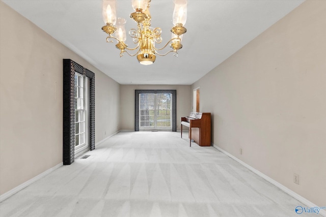 corridor featuring light colored carpet and a notable chandelier