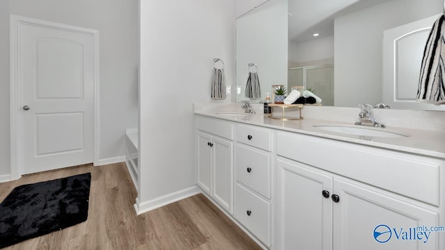 bathroom featuring vanity, shower with separate bathtub, and hardwood / wood-style flooring