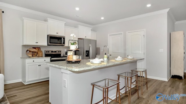 kitchen featuring stainless steel appliances, white cabinetry, a kitchen island with sink, and light hardwood / wood-style flooring