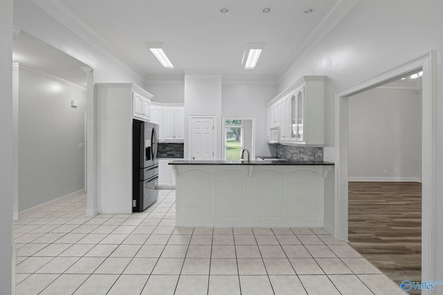 10214 New Cut Rd, Athens, AL 35611 - kitchen featuring stainless steel fridge with ice dispenser, dark countertops, a peninsula, tasteful backsplash, and ornamental molding