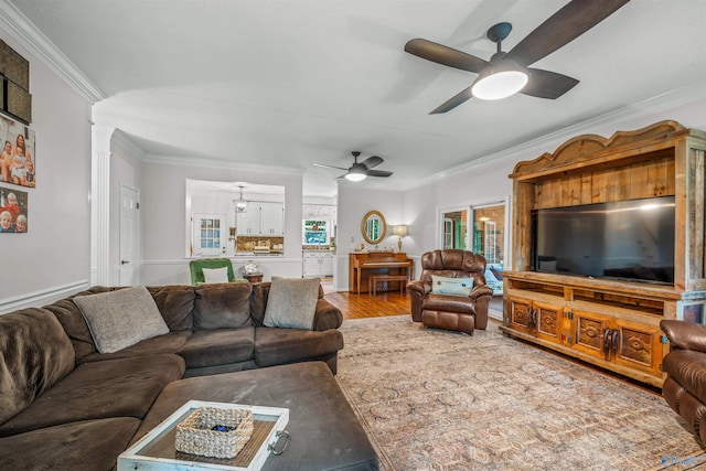 living room with hardwood / wood-style floors, crown molding, and ceiling fan