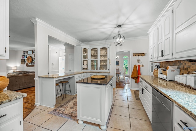 kitchen featuring white cabinets, light tile patterned floors, light stone counters, and a kitchen island