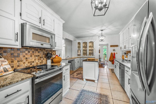 kitchen featuring light tile patterned flooring, appliances with stainless steel finishes, light stone counters, crown molding, and white cabinets