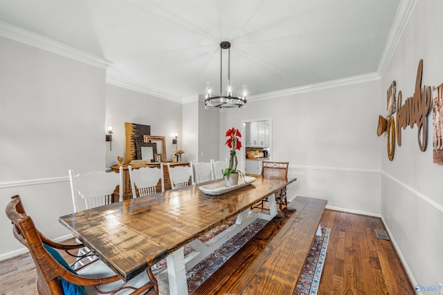 dining room with crown molding, a chandelier, and hardwood / wood-style flooring