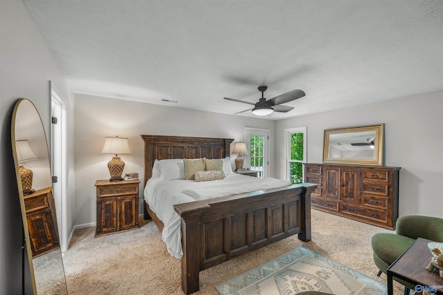 carpeted bedroom featuring a textured ceiling and ceiling fan