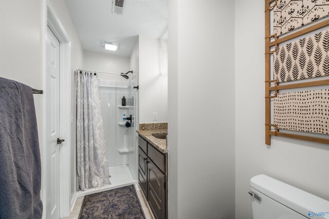 bathroom featuring curtained shower, vanity, and toilet