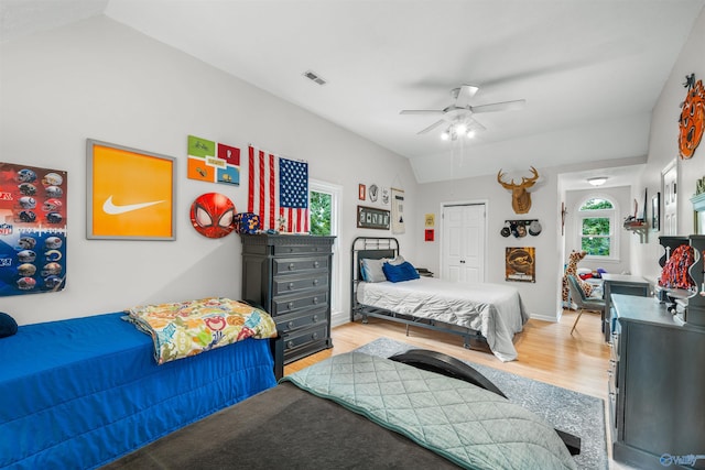 bedroom featuring ceiling fan, light hardwood / wood-style flooring, a closet, and lofted ceiling