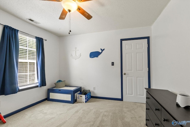 interior space with light carpet, baseboards, visible vents, and a textured ceiling