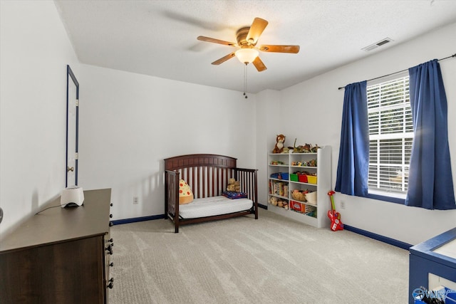 bedroom with carpet floors, visible vents, a ceiling fan, a textured ceiling, and baseboards