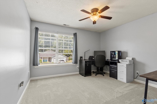 office area with light carpet, a ceiling fan, baseboards, and a textured ceiling