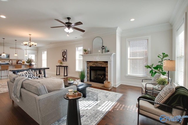 living area featuring a healthy amount of sunlight, baseboards, ornamental molding, and dark wood finished floors